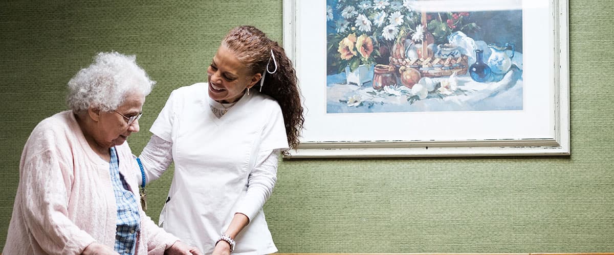 Caregiver assisting a resident at Embassy Oaks healthcare facility