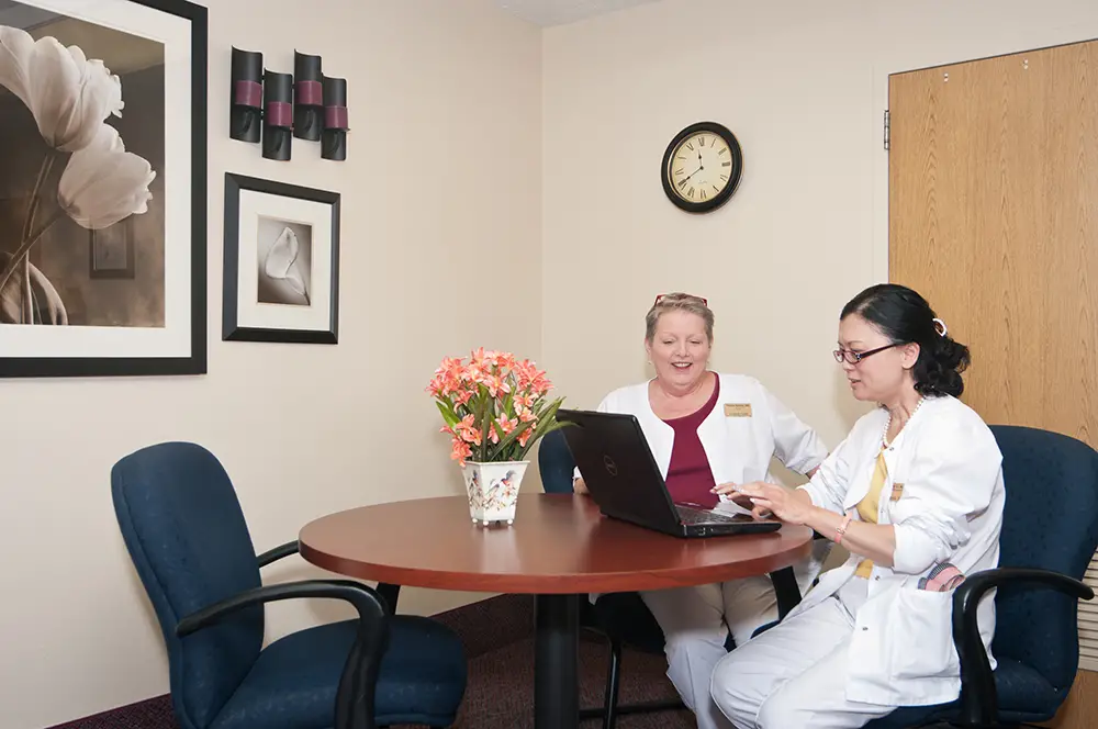Elderly woman reviewing admissions paperwork with a family member