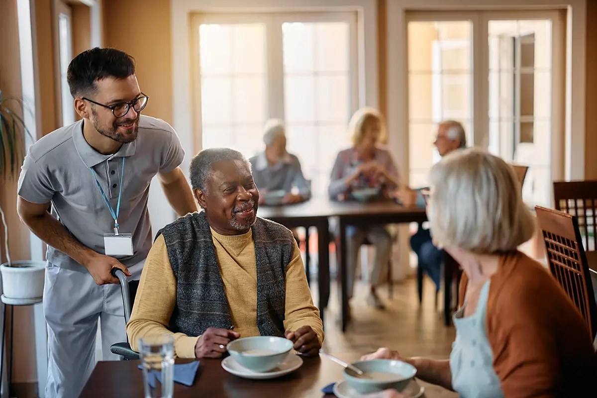 Staff members interacting warmly with residents in an assisted living community