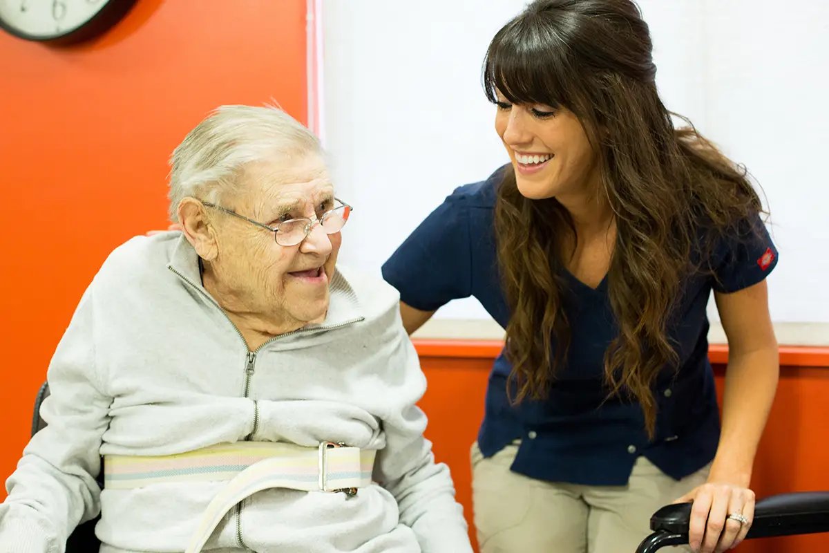 Healthcare provider assisting an elderly patient with cardiac care needs