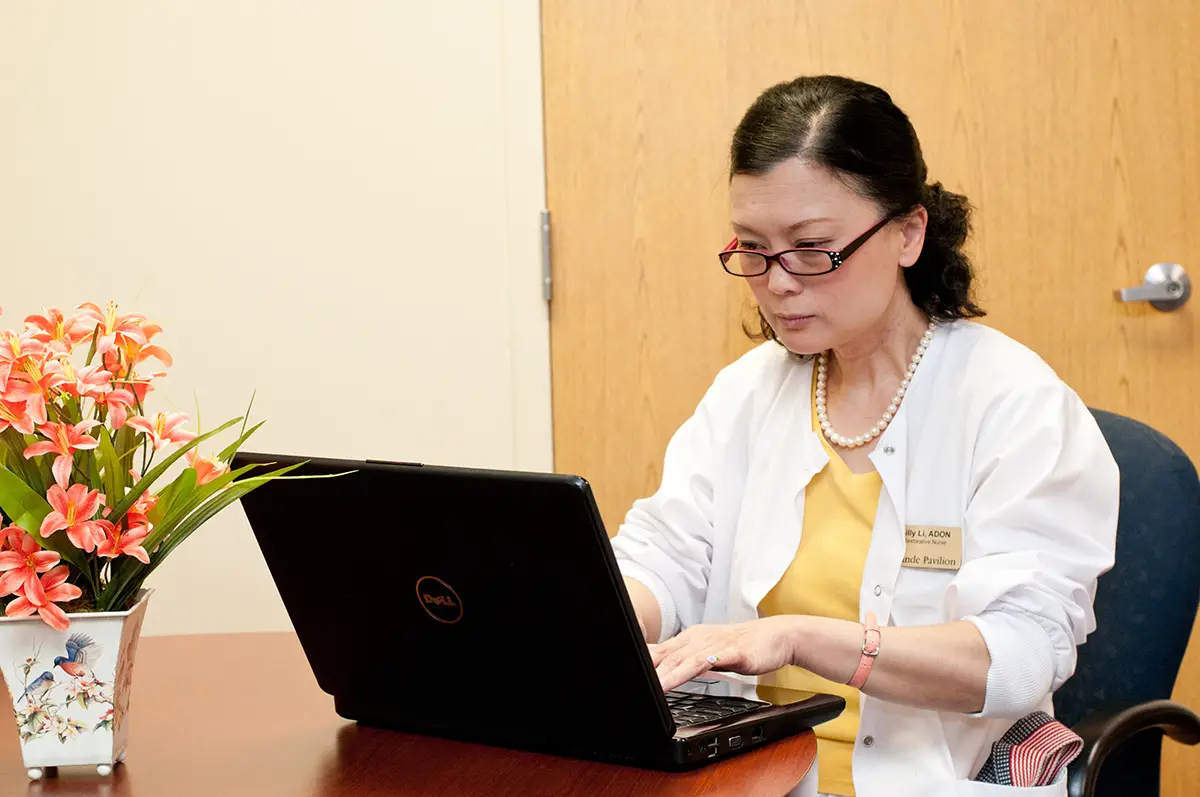 Nurse bringing flowers to a smiling elderly woman in a care setting