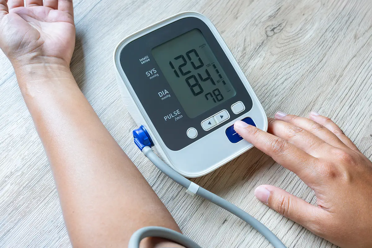 Patient using blood pressure monitor as part of diabetes management care