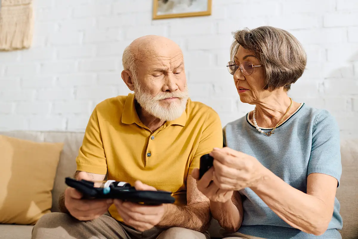 Elderly man and a companion reviewing diabetes self-management educational materials