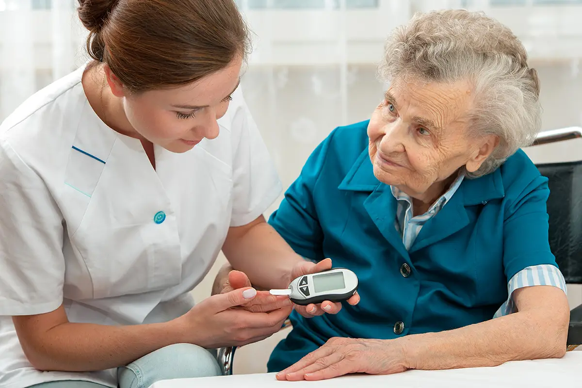 Healthcare provider assisting an elderly diabetes care patient