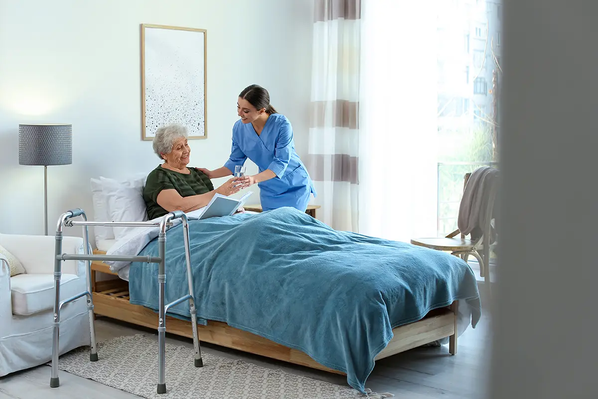 Caregiver sitting beside an elderly hospice care patient in a comfortable setting