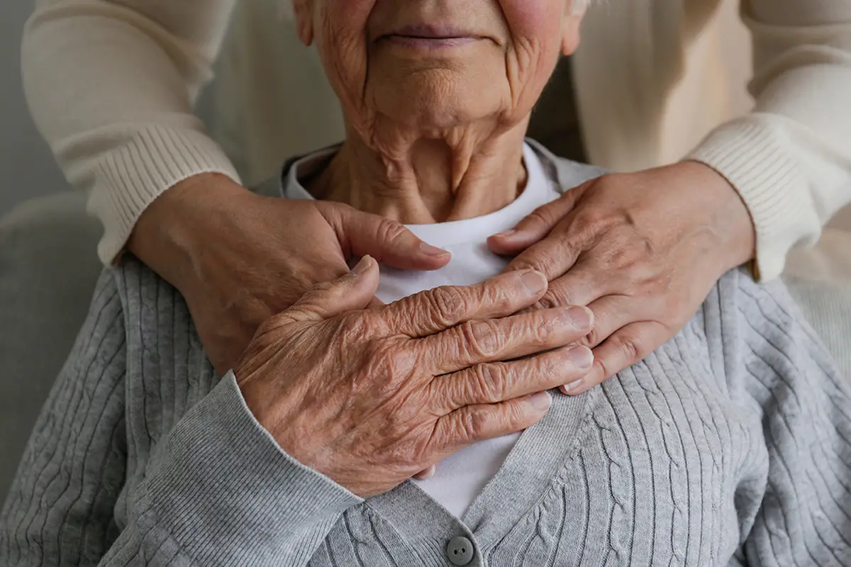 Compassionate caregiver holding hands with an elderly hospice care patient
