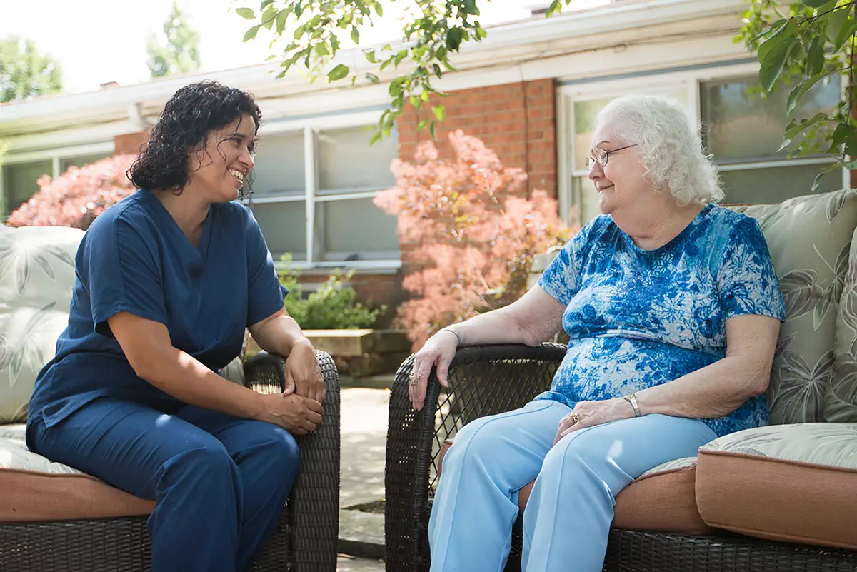 Staff member showing an elderly couple around an assisted living facility