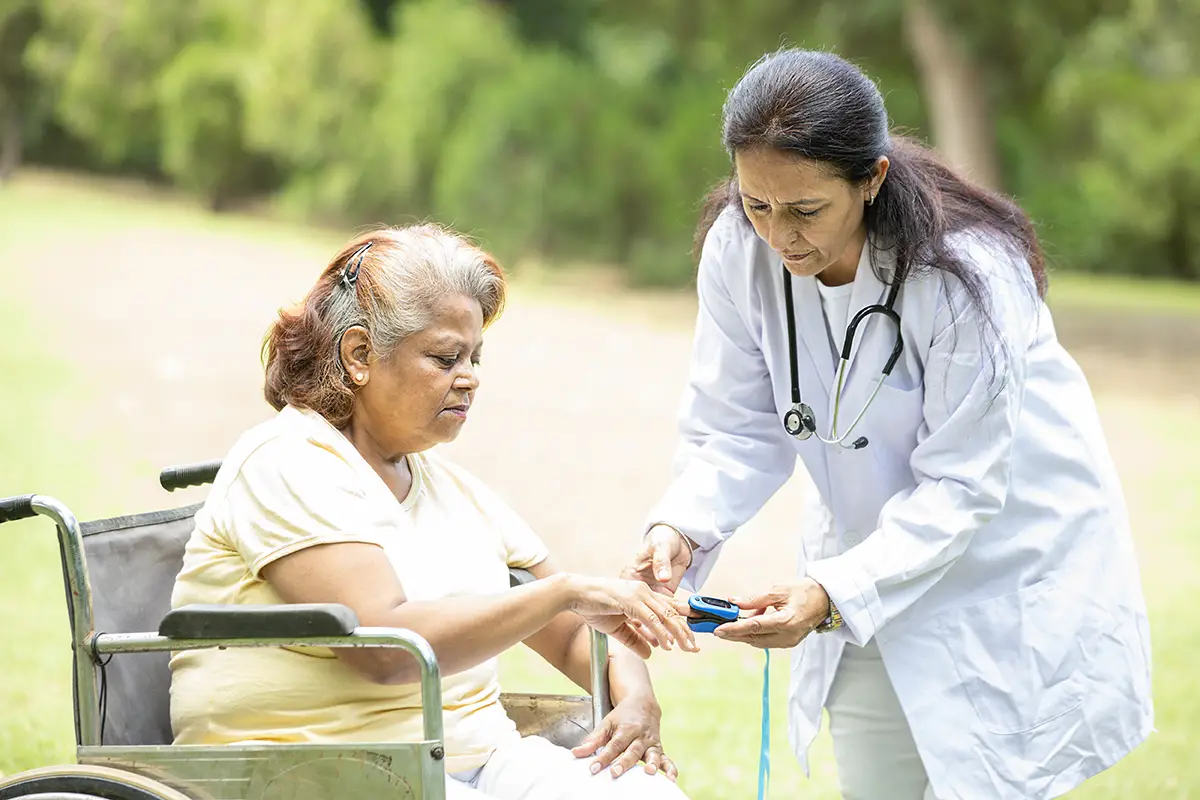Elderly woman receiving IV therapy with continuous monitoring from a healthcare provider