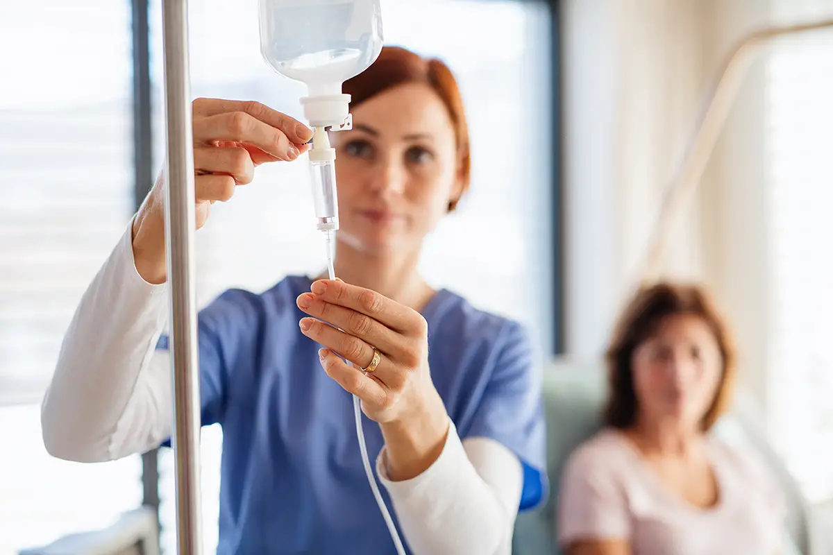 Nurse preparing IV therapy treatment for a patient