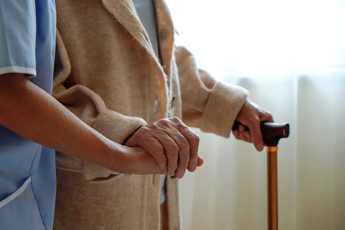Caregiver assisting an elderly woman with daily activities in long-term care