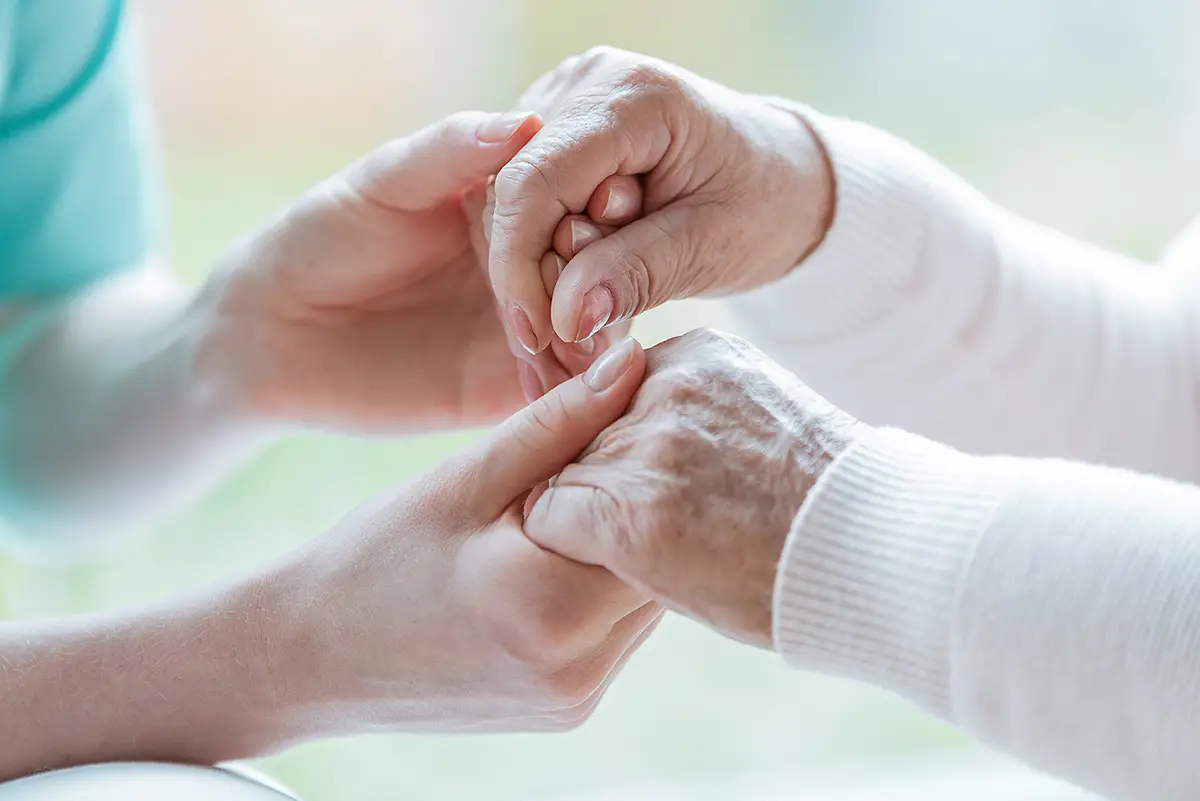 Elderly woman sitting peacefully, receiving memory care support
