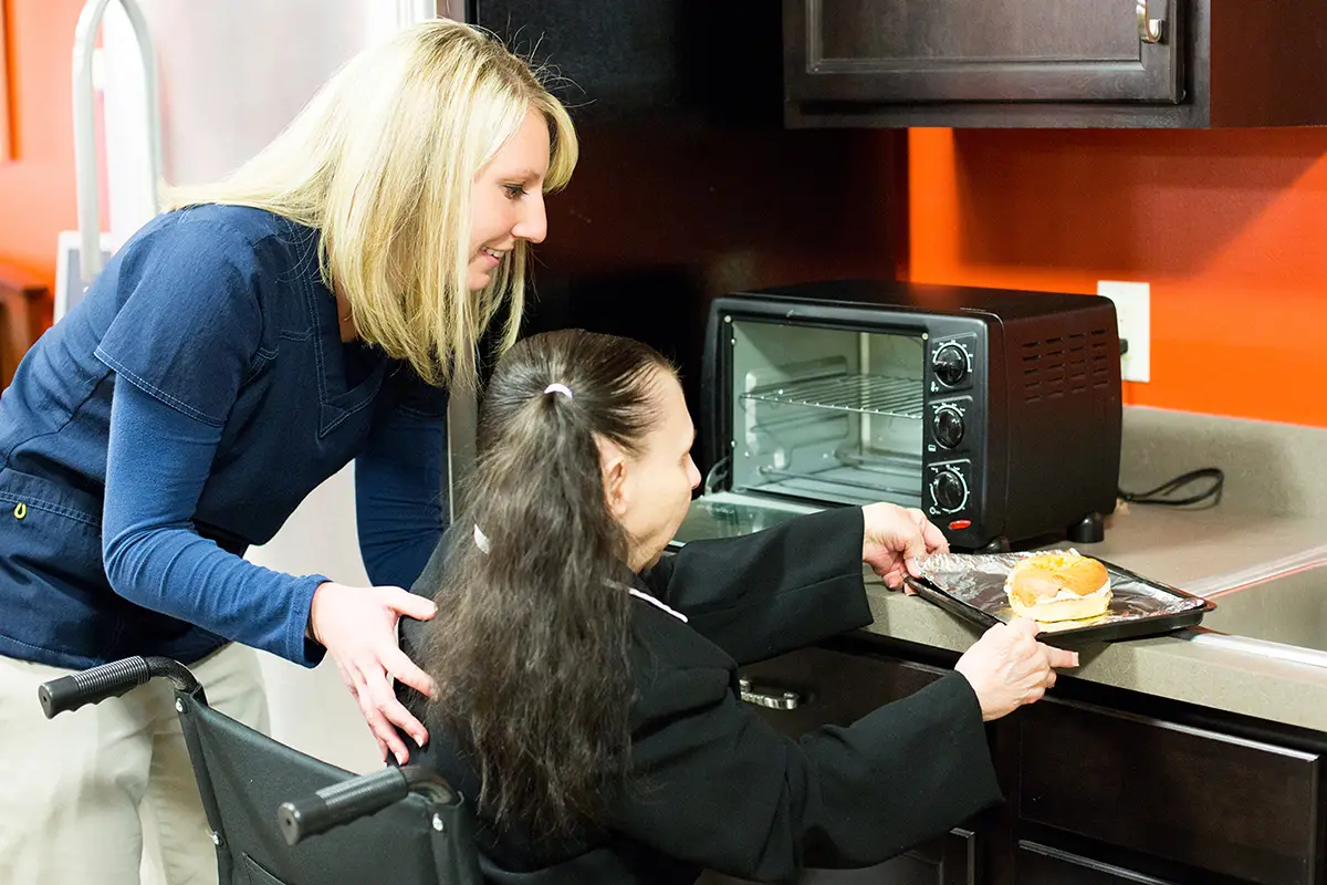 Caregiver assisting elderly residents with nutritious meal preparation