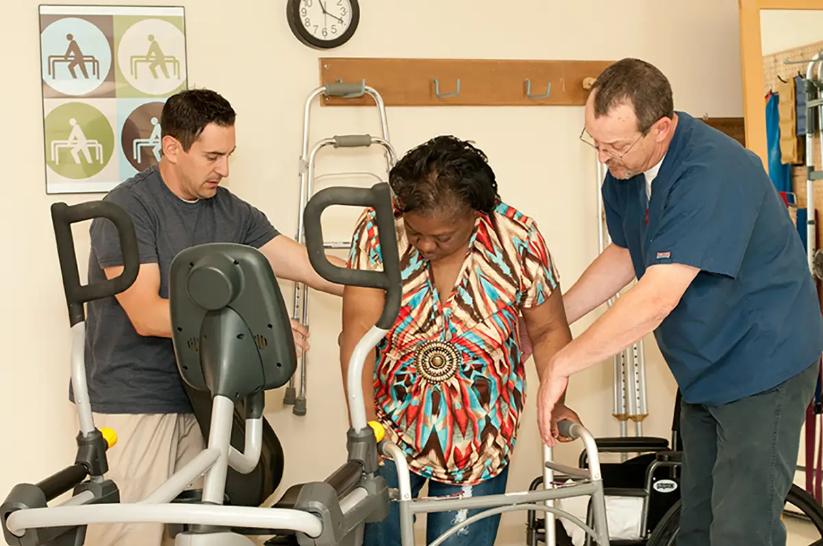 Therapist assisting an elderly patient with orthopedic rehabilitation exercises