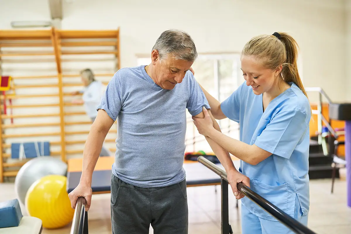 Therapist helping a patient regain independence through rehabilitation therapy