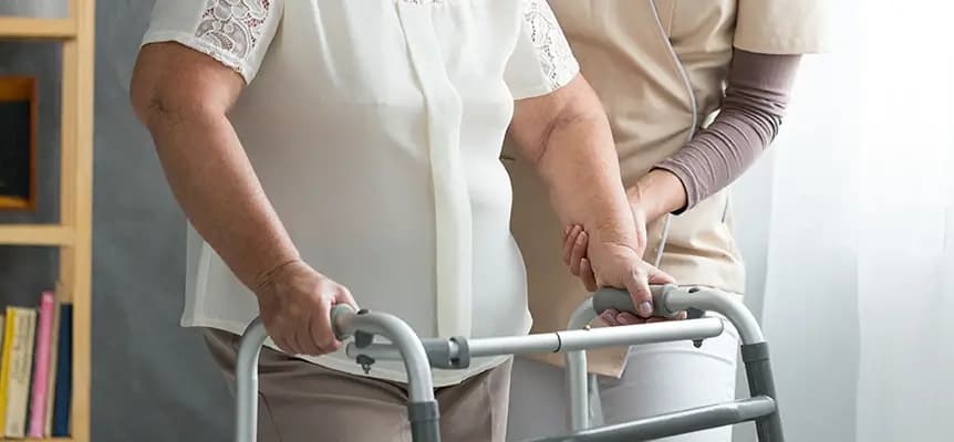 Patient receiving post-surgical rehabilitation therapy with a walking aid