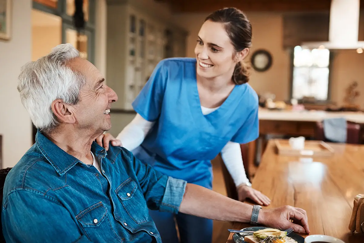 Caregiver helping an elderly resident with nutritional support and diet planning for renal care