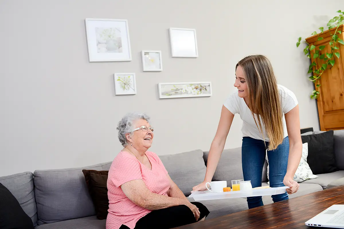 Caregiver and elderly woman enjoying nutritious meals during respite care