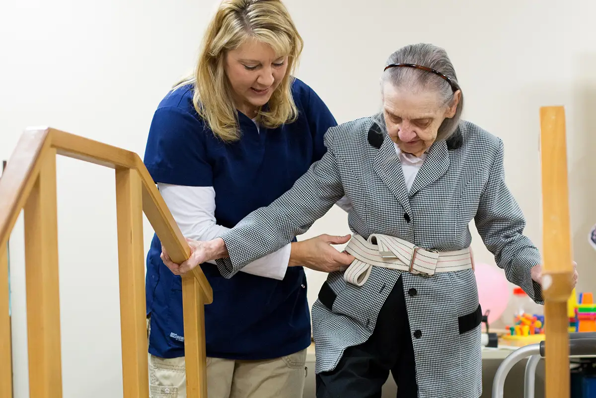 Skilled nursing staff helping an elderly patient with physical rehabilitation