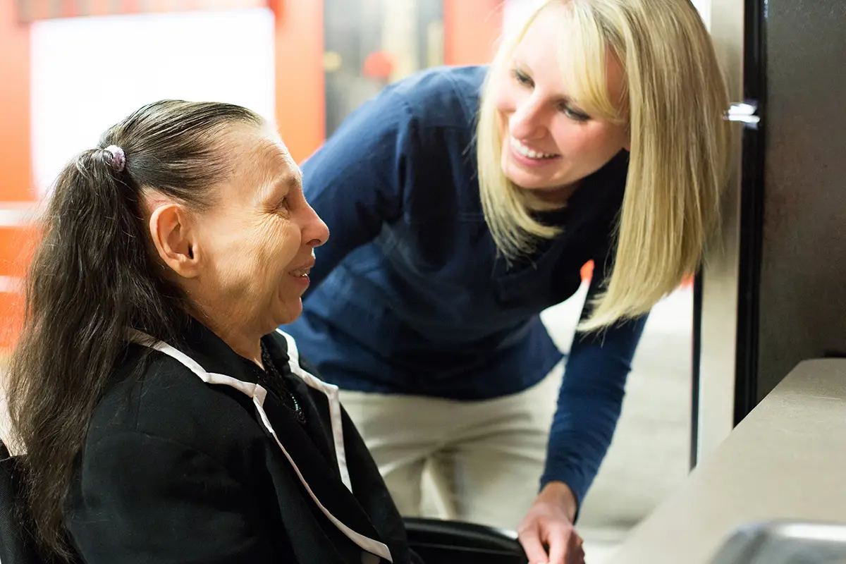 Skilled nursing staff member providing attentive care to an elderly resident