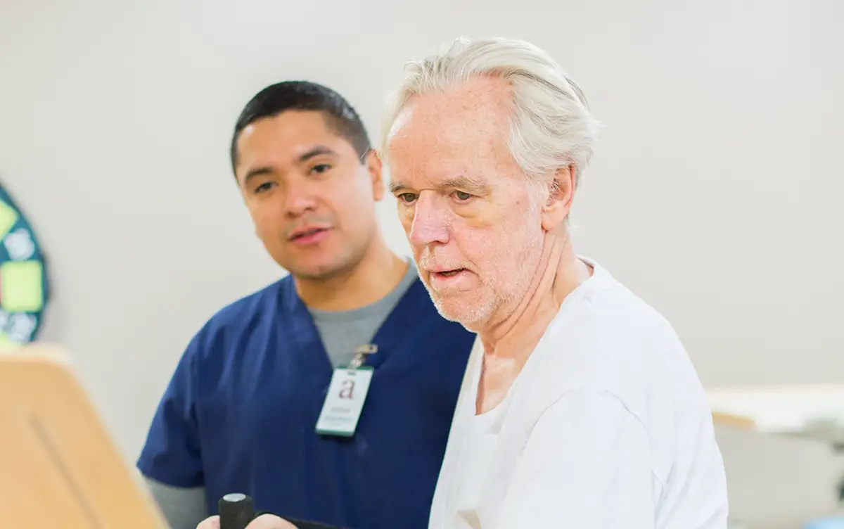 Caregiver assisting a patient, demonstrating why families choose Embassy Healthcare