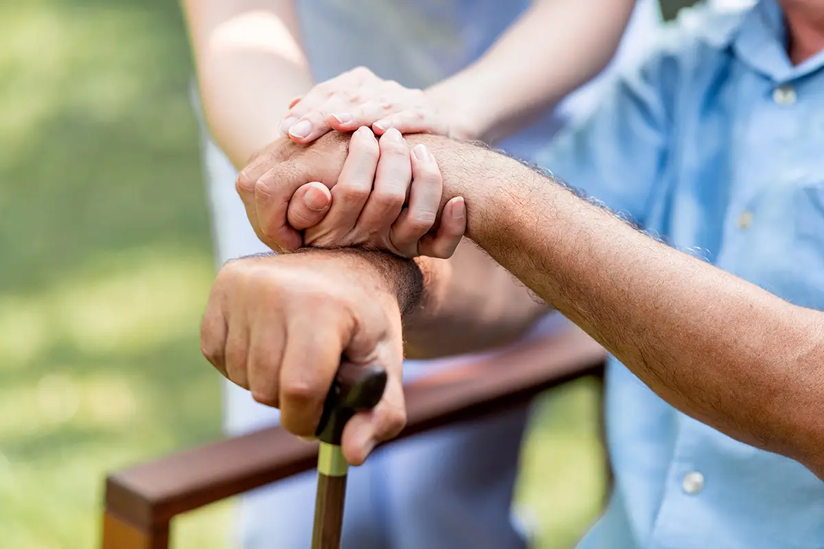 Nurse providing attentive wound care to an elderly patient's hand