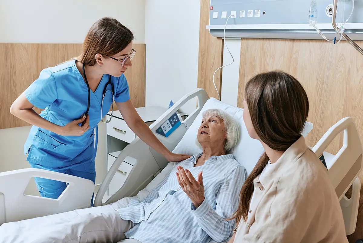Caregiver gently holding an elderly patient's hands during wound care pain management