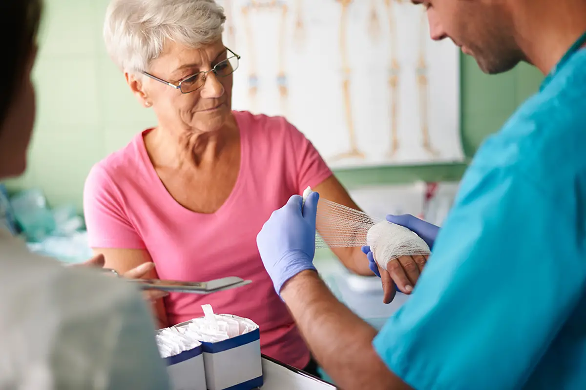 Nurse performing wound cleaning and dressing change for a patient