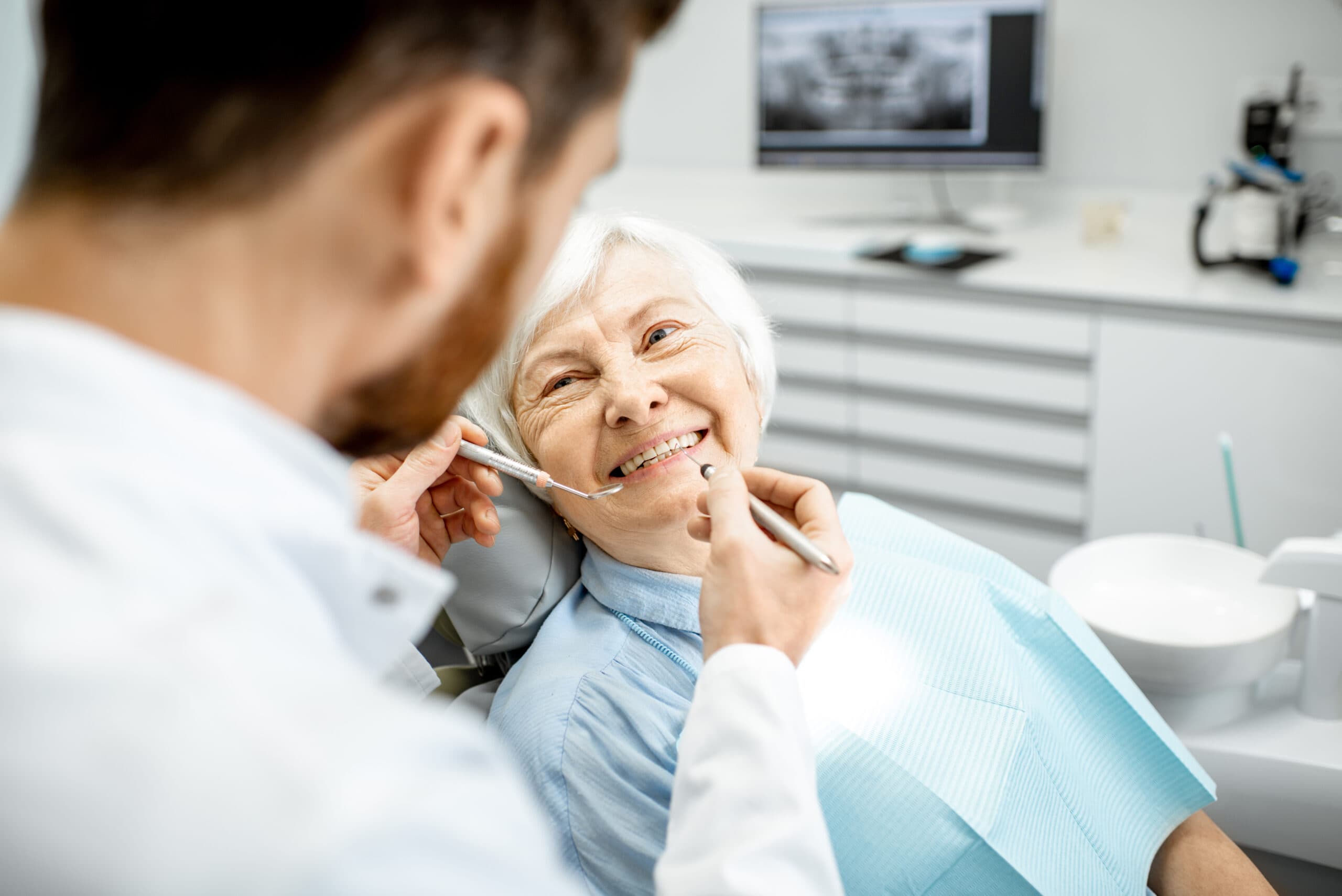 an elderly woman getting their teeth examined