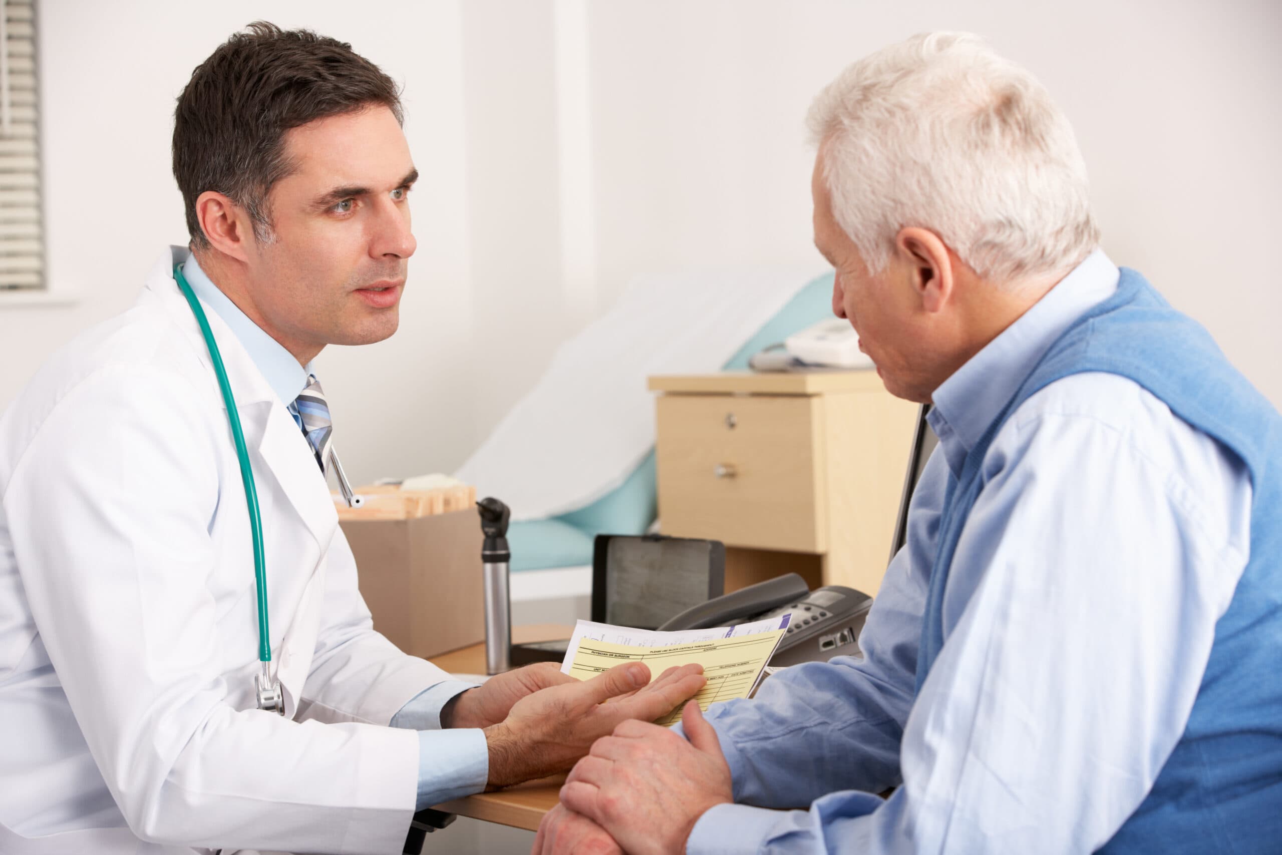 Doctor in a white coat talking with an older man during a medical appointment
